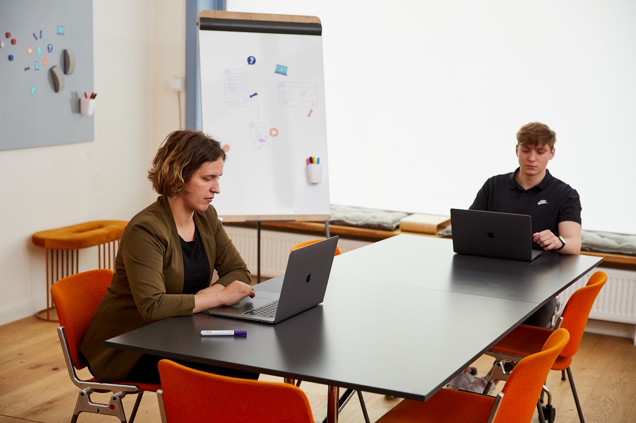 Coworking Meetings in der Kabine Zwei Coworker haben ein Meeting mit Flipchart und Laptop